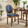 Sheesham wood upholstered dining chair with cushioned seat and oval backrest placed beside a wooden dining table